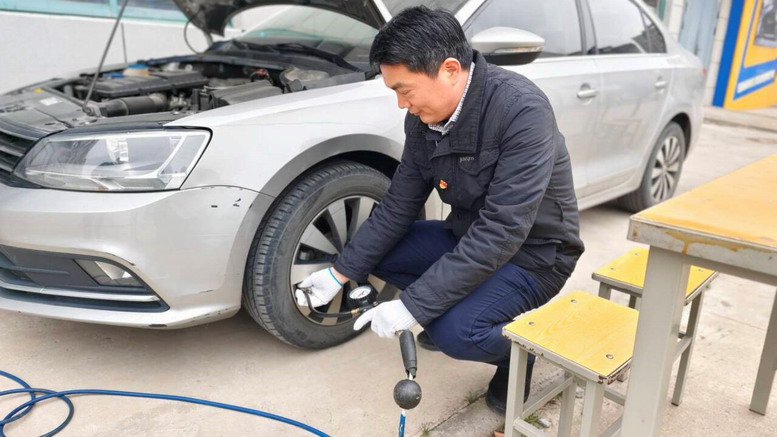 汽車工程學院黨員教師為教職工車輛充氣